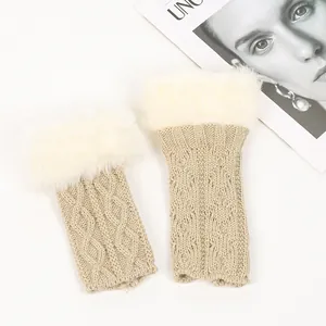 Détail des mitaines en maille beige avec une bordure en fausse fourrure blanche.