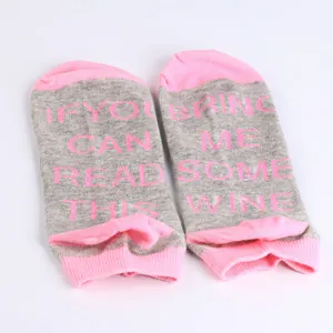 Close-up detail of grey and pink cotton ankle socks with funny letters on the sole