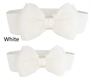 Detail van crèmewitte elastische tailleband met een grote decoratieve chiffon strik.