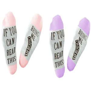 Close-up of cotton socks with funny 'If you can read this, bring me chocolate' text on soles.