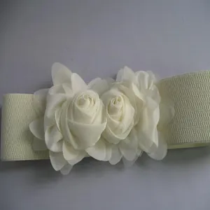 Detailed view of cream fabric roses on a wide elastic waist belt for dresses.