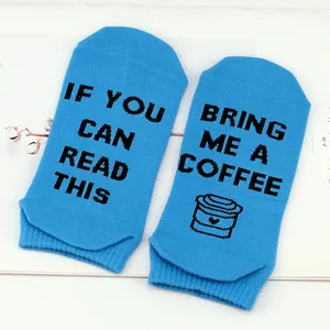 Close-up detail of blue cotton ankle socks featuring humorous 'Bring Me a Coffee' text print