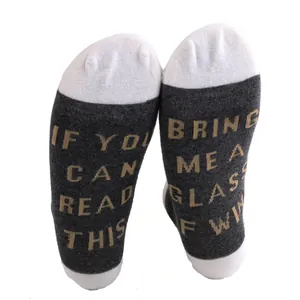Detailed close-up of novelty cotton socks featuring funny wine quote text on the soles