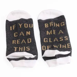 Detailed view of grey and white ankle socks featuring a funny Bring Me Wine quote