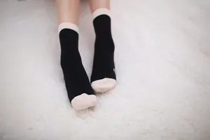 Detail view of unisex mid-calf cotton socks in black and beige contrast color