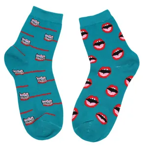 Nahaufnahme von stylischen blaugrünen Baumwollsocken mit Lippen- und Zahnbürstenmuster.