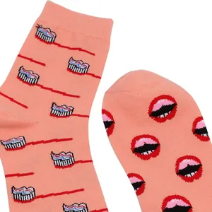 Detailansicht trendiger Pfirsich-Baumwollsocken mit Lippen- und Zahnbürstenillustrationen