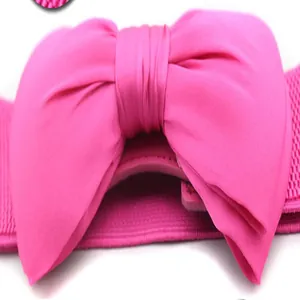 Gedetailleerd aanzicht van een magenta chiffon strik op een elastische damesriem