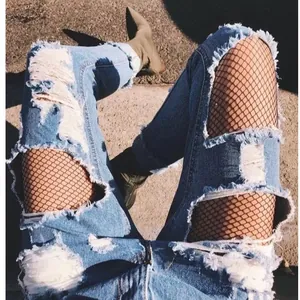 Sexy black fishnet pantyhose for women styled with ripped denim jeans for street look