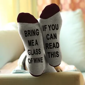 Detail view of cotton socks with 'If you can read this bring me wine' slogan print