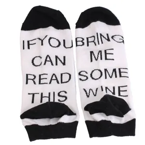 Close-up detail of black and white novelty ankle socks featuring Bring Me Some Wine print
