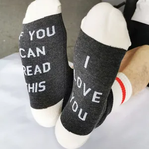 Close-up of cotton socks with 'IF YOU CAN READ THIS I LOVE YOU' text on soles