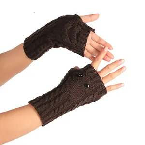 Detail van bruine gebreide vingerloze uil-handschoenen met zwarte kraalogen decoratie