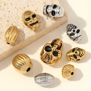 Primo piano di perline a teschio oro e argento e distanziali zigrinati per gioielli.
