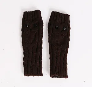 Donkerbruine gebreide vingerloze handschoenen met schattig uilenmotief en zwarte knoopogen.