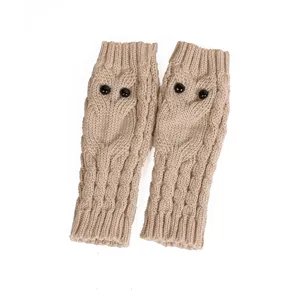 Gedetailleerd overzicht van beige gebreide vingerloze uil handschoenen met zwarte kralenogen