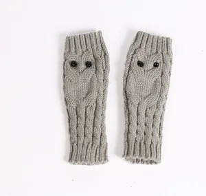 Gedetailleerde weergave van grijze gebreide vingerloze handschoenen met uilenpatroon