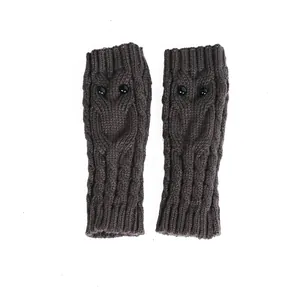 Gedetailleerde close-up van bruine gebreide uil-vingerloze handschoenen met zwarte knoopogen