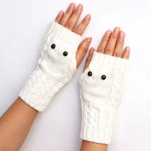 Detail van witte uil-vormige gebreide vingerloze handschoenen voor extra winterwarmte.