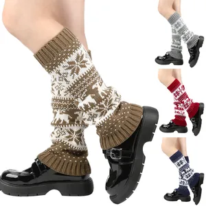 Close-up detail of knitted Christmas leg warmers featuring snowflake and reindeer patterns
