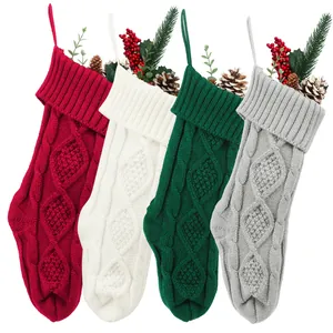 Vue détaillée de quatre grandes chaussettes de Noël en tricot avec des baies festives.