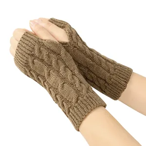 Close-up of brown cable-knit fingerless gloves showing intricate knitted texture and pattern