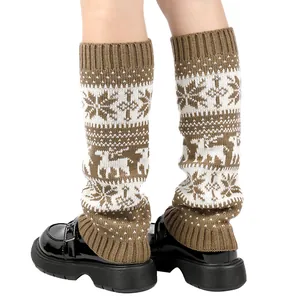 Close-up detail of knitted Christmas leg warmers featuring snowflake and reindeer patterns