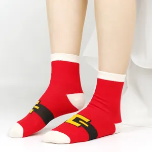 Close-up of festive red Christmas socks with Santa belt design for kids and adults