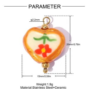 Détail d'un pendentif en céramique en forme de cœur avec motif floral et dimensions