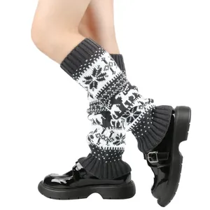 Detail view of knitted leg warmers featuring Christmas snowflake and reindeer patterns