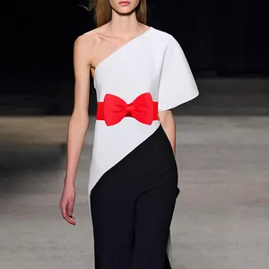 Close-up detail of a vibrant red elastic bow waist belt shown on a stylish model