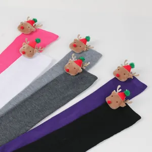 Detail of colorful Christmas thigh-high socks with cute 3D reindeer plush decorations.