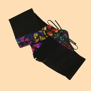 Detailed macro shot of a black elastic corset belt with vibrant neon butterfly print