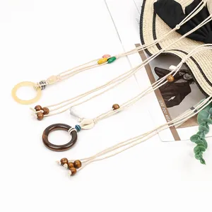 Detailed view of handmade bohemian woven waist chains featuring wooden beads and seashell charms