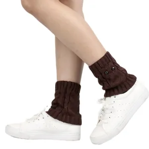 Cozy brown knit owl leg warmers with cute beaded eye details worn on white sneakers.
