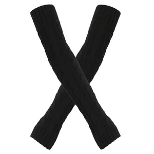 Detailopname van zwarte gebreide armwarmers met een 8-vormig vlechtpatroon