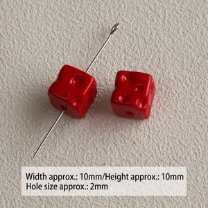 Macro view of small red acrylic cheese-shaped cube beads for DIY jewelry making