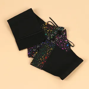 Detail of black corset belt featuring vibrant rainbow star print and lace-up design