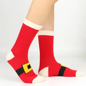 Close-up of festive red Christmas calf-high socks featuring a Santa belt design on a white background
