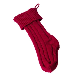 Vue détaillée de la chaussette de Noël rouge en tricot torsadé sur fond blanc pur
