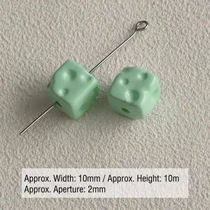 Close-up detail of mint green acrylic cheese-shaped cube beads with 10mm dimensions