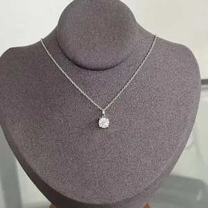 Detail view of a minimalist 14k gold-filled necklace with a round moissanite pendant