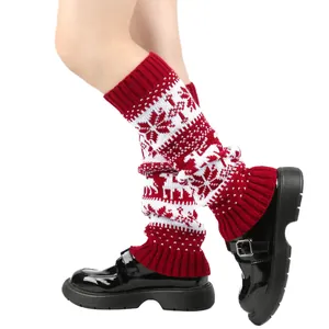 Detail of red and white knitted leg warmers with Christmas snowflake and reindeer patterns