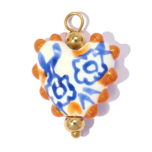 Détail macro du pendentif en céramique en forme de cœur avec motif floral bleu