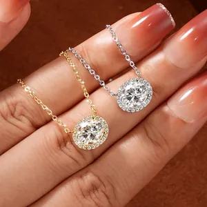 Detailed macro view of two oval-cut moissanite halo pendant necklaces in gold and silver