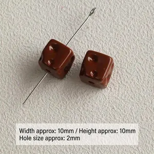 Detailed close-up of small brown acrylic cheese-shaped square beads with 2mm hole