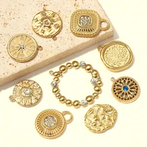 Macro view of gold-plated stainless steel pendants with relief sun and compass designs
