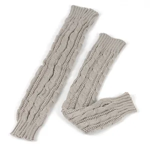 Gedetailleerd overzicht van grijze kabelgebreide armwarmers met duimgat voor winterse warmte.