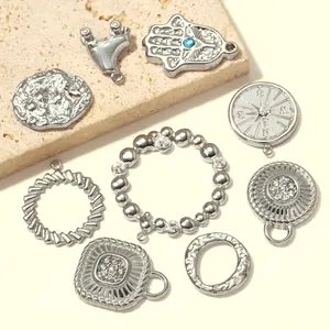 Detailed view of assorted stainless steel pendants including Hamsa hand and compass designs