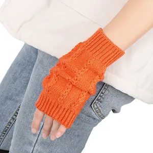 Nahaufnahme der detaillierten Zopfmuster-Textur orangefarbener fingerloser Handschuhe